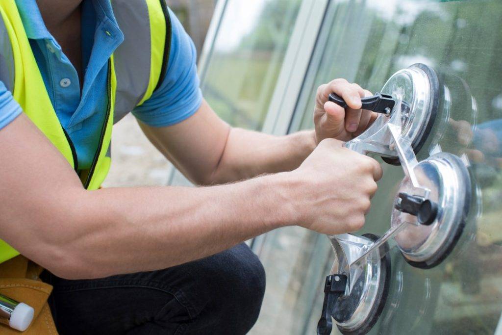 A double glazed window being fitted by a workman.
