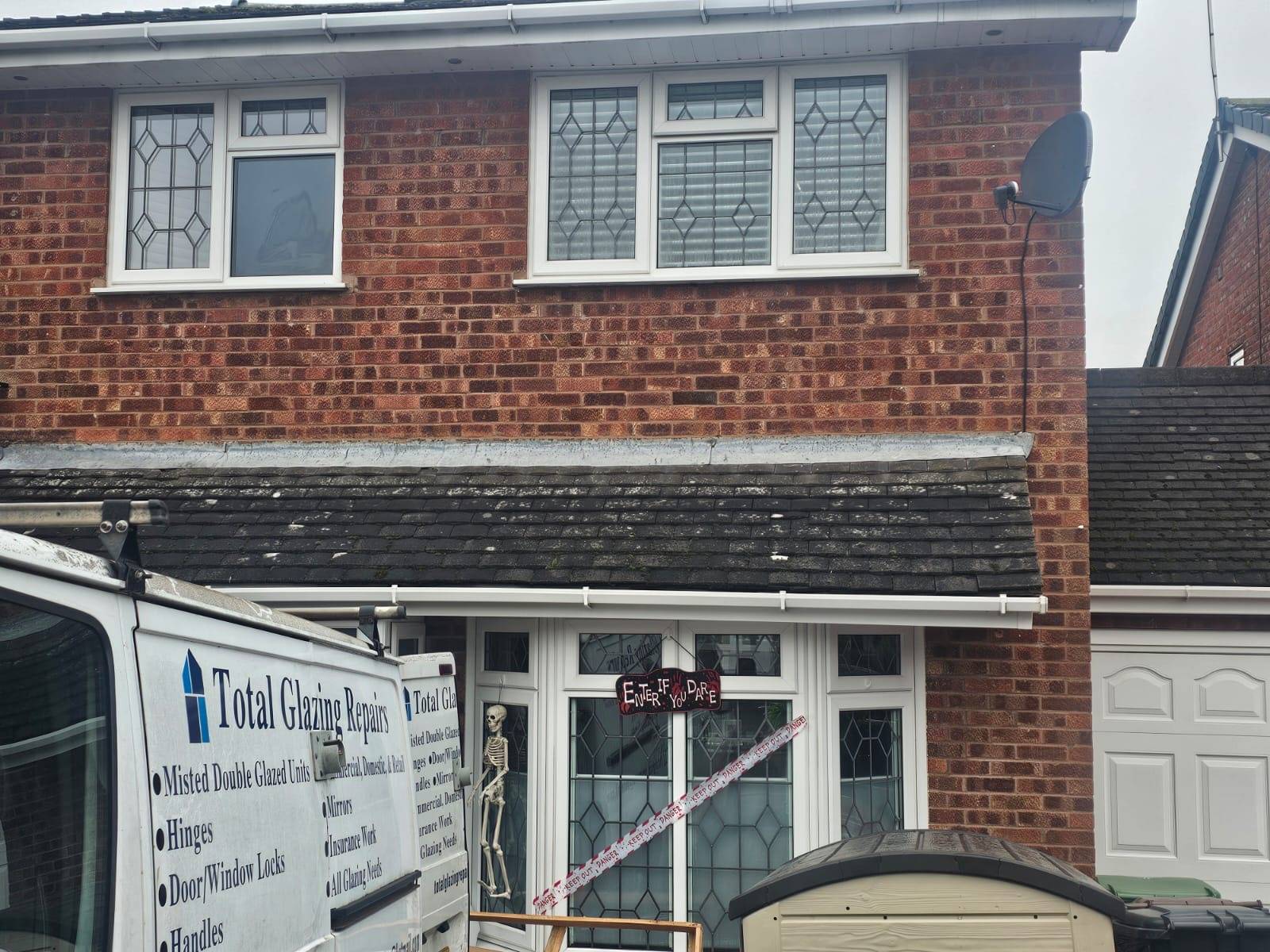 House with red bricks and some Halloween decorations on the front door. Featuring a Total Glazing Repairs van outside.
